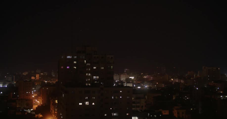 Aerial view of buildings in a city at night is displayed