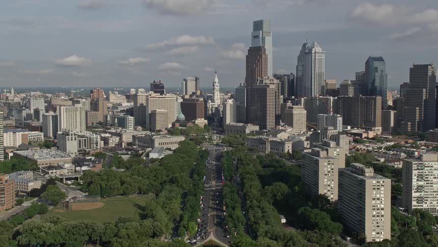Flying over the Philadelphia Museum of Art this aerial clip approaches City Hall in downtown Philadelphia showcasing the citys historic landmarks and high-rise buildings surrounded by partly cloudy skies