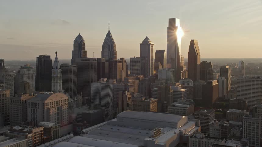 Approaching the Downtown Philadelphia skyline and convention center with partly cloudy skies during sunset