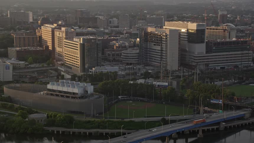 A baseball field near a freeway in a metropolis during the day