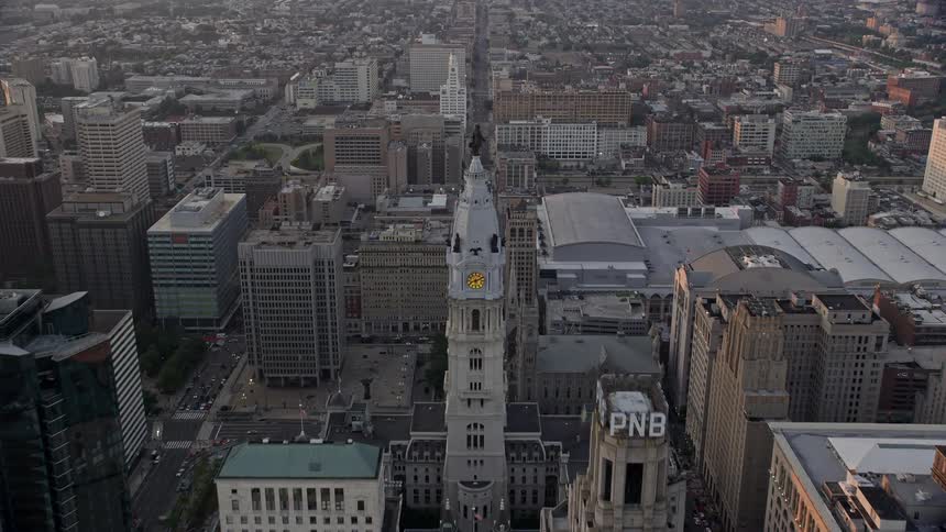 Approaching the iconic William Penn statue atop Philadelphias City Hall amid a hazy sunset