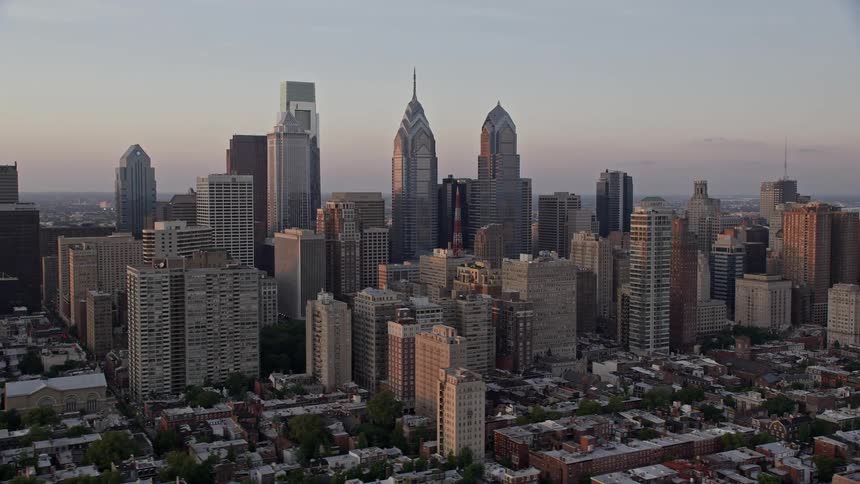 Aerial footage captures stunning skyscrapers and towers standing tall over the metropolis of downtown Philadelphia at sunset
