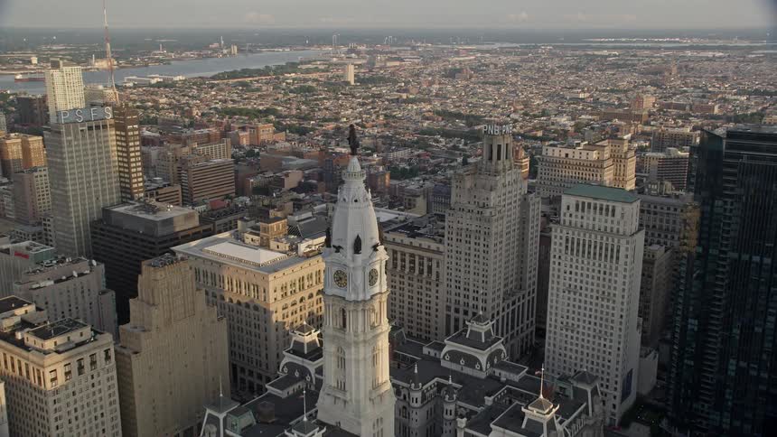 Approaching the famous William Penn statue atop Philadelphias City Hall at dusk via aerial footage during sunset