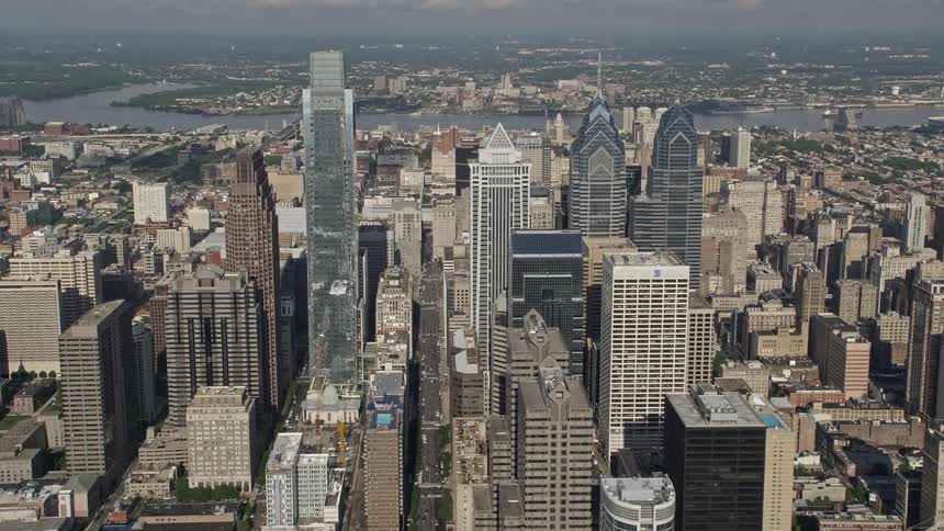Aerial footage of Philadelphias downtown area showcasing towering skyscrapers and iconic structures such as the city hall and convention center shot during the daytime