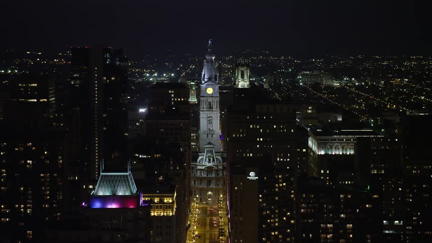 A stunning aerial view of Philadelphias iconic City Hall with statues of William Penn and others visible at night