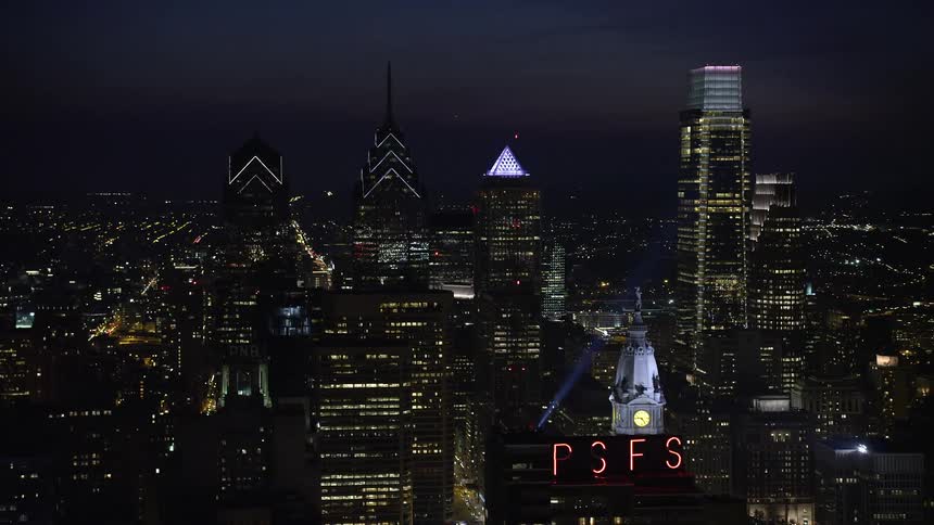 Aerial view of City Hall clock tower and downtown Philadelphia skyscrapers lit up at night