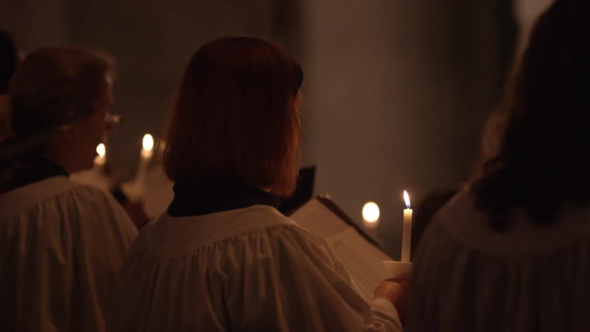 Choir members perform by candlelight