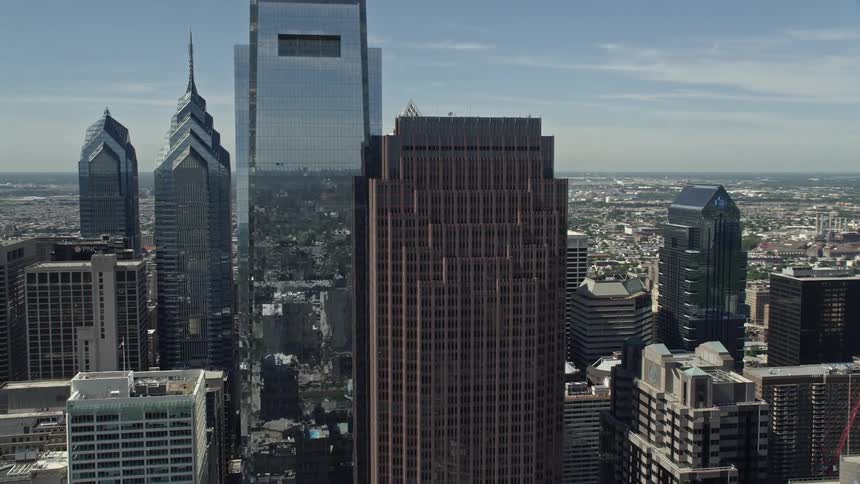 A breathtaking aerial view of Comcast Center and Three Logan Square high rise towers in sunny downtown Philadelphia Pennsylvania during daytime