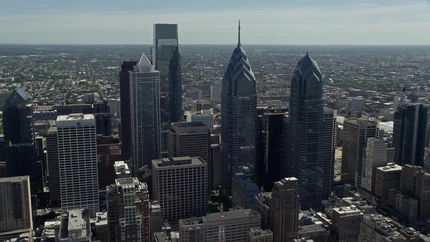 Aerial footage of towering skyscrapers and modern buildings in downtown Philadelphia Pennsylvania on a sunny day