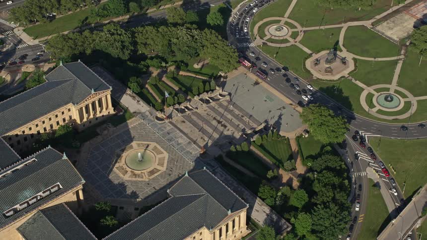 Aerial footage circling Philadelphia Museum of Art and Washington Monument Fountain in Pennsylvania on a partly cloudy day