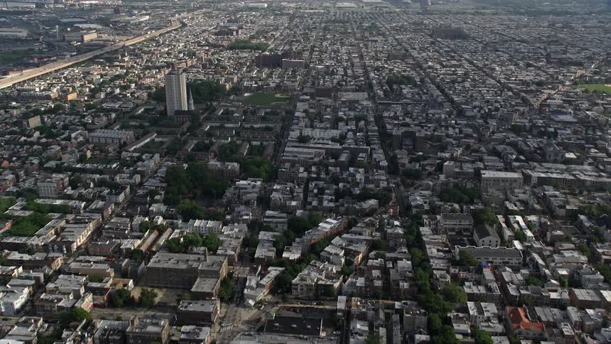 Aerial footage of townhouses and apartment buildings in Philadelphias densely populated South Philly neighborhood during the day