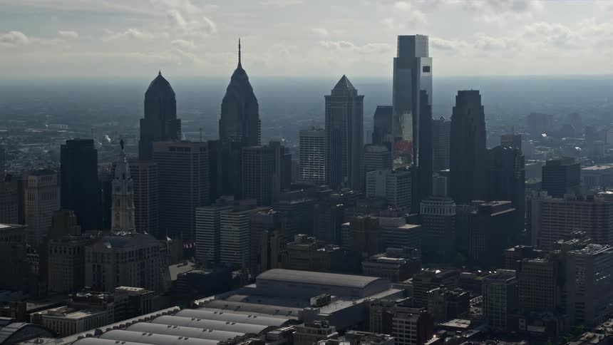 Aerial view of tall skyscrapers in downtown Philadelphia during the daytime in haziness