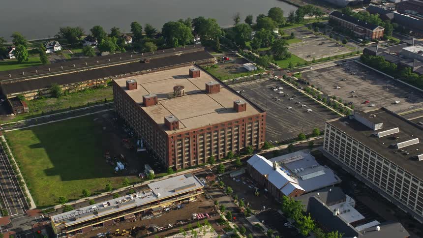 Aerial stock footage of a factory building located at The Navy Yard in Philadelphia during the daytime
