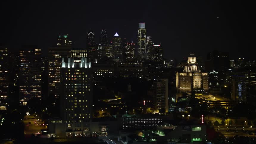 aerial footage of the historic Downtown Philadelphia skyline at night with a reveal of the famous United States Customs House and the historic ship Pennsylvania
