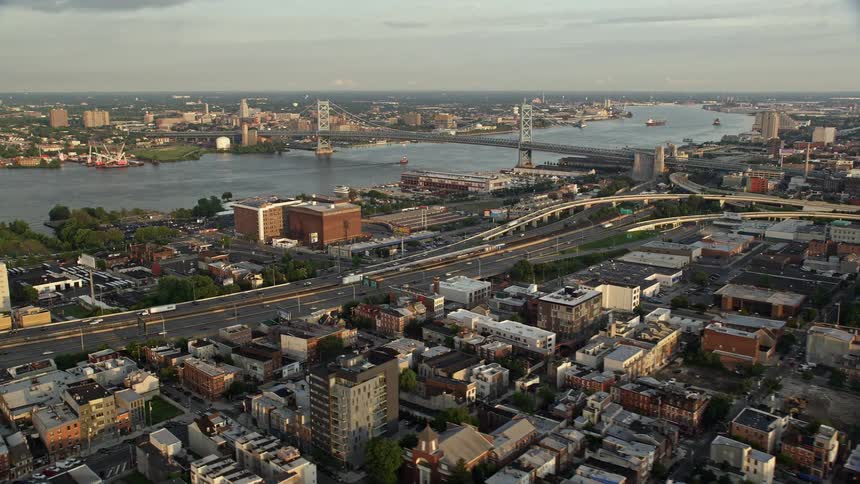 A stunning aerial footage of Benjamin Franklin Bridge over Delaware River seen from I-95 in North Philadelphia during sunset