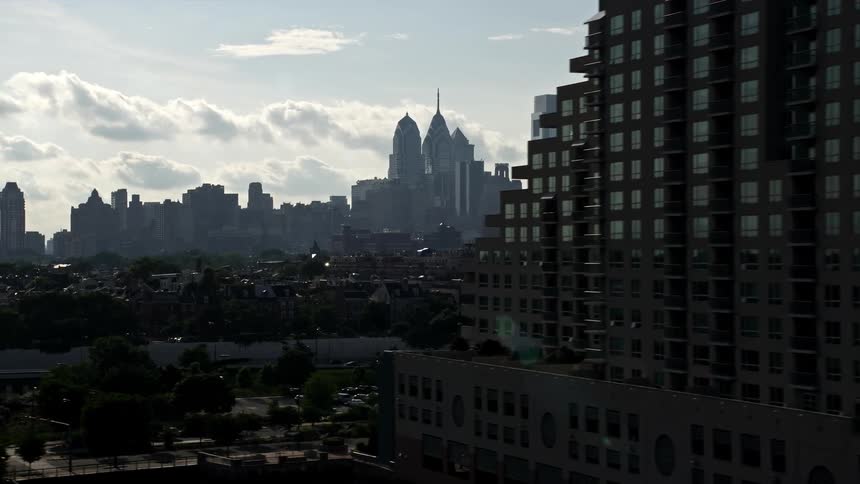 An aerial view of Downtown Philadelphias skyline with superstructures supertalls towers and buildings on a partly cloudy day
