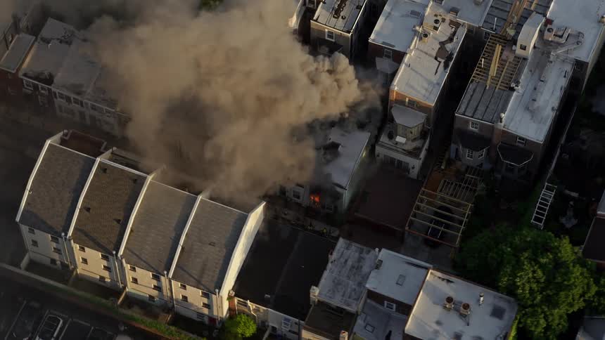 Aerial footage captures thick smoke billowing from a residential fire near Downtown Philadelphia at sunset