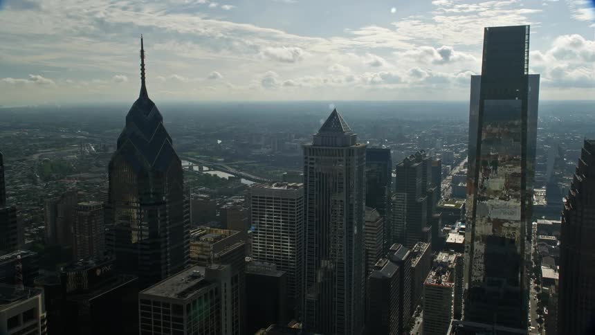 Approaching Philadelphia City Hall and tall Downtown skyscrapers in Pennsylvania in a haze as seen from an aerial perspective