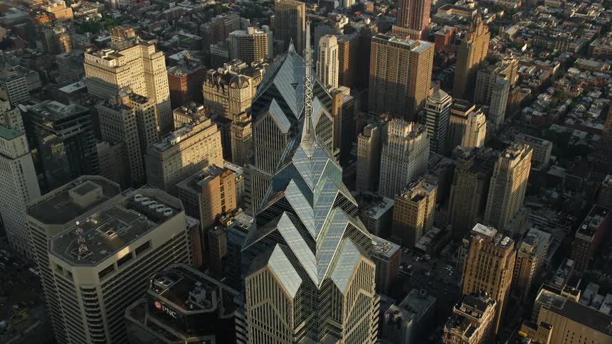 Aerial footage captures One and Two Liberty Place skyscrapers in Downtown Philadelphia during sunset from a birds eye perspective
