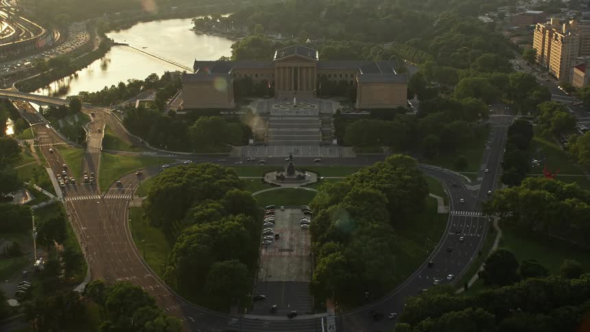 Aerial footage of Philadelphias iconic Oval park and Museum of Art fountain at dusk during sunset