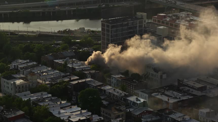 Aerial footage of a thick smoke arising from a residential fire in Downtown Philadelphia during sunset