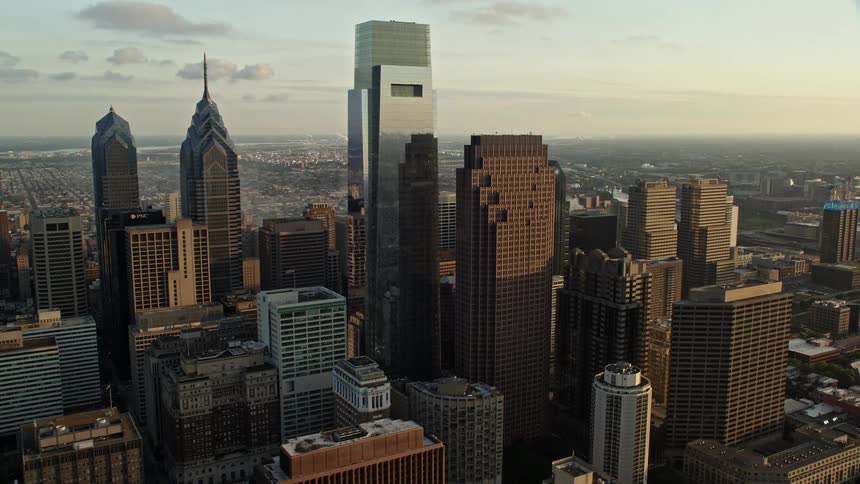 Fly above the modern skyscrapers of downtown Philadelphia during the sunset