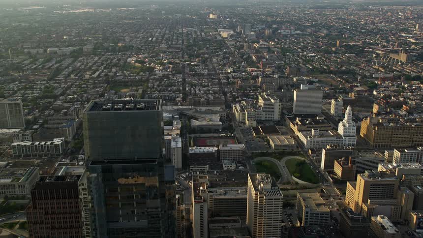 A stunning aerial view captures the skyscrapers neighborhoods and buildings of Downtown Philadelphia Pennsylvania in the shade of a beautiful sunset
