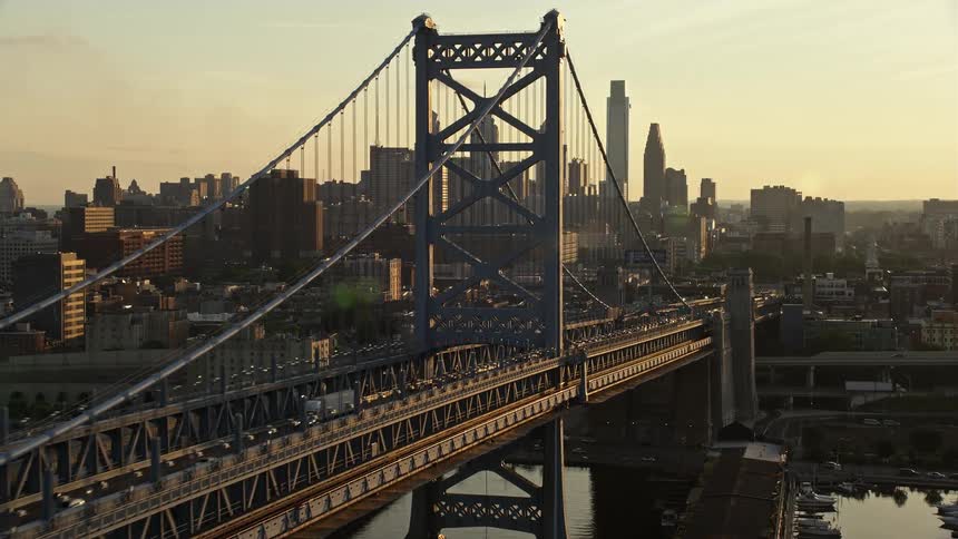 A stunning aerial view of Downtown Philadelphia and the Benjamin Franklin Suspension Bridge at sunset