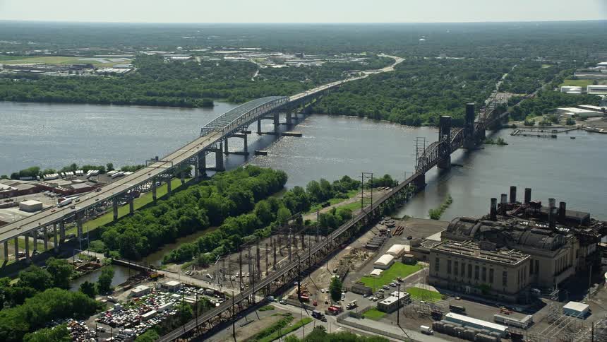 An aerial view of the Betsy Ross Bridge spanning over the Delaware River with the abandoned Richmond Substation in the background in North Philadelphia PA