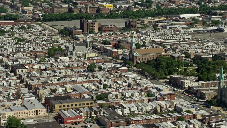 Aerial footage of churches in an urban neighborhood of North Philadelphia Pennsylvania on a sunny day