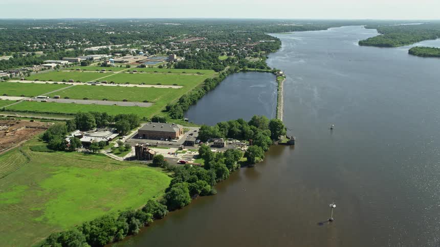 Aerial footage of Philadelphia Fire Academy near the Delaware River featuring hazy day views river approach and firefighting training shot during midday