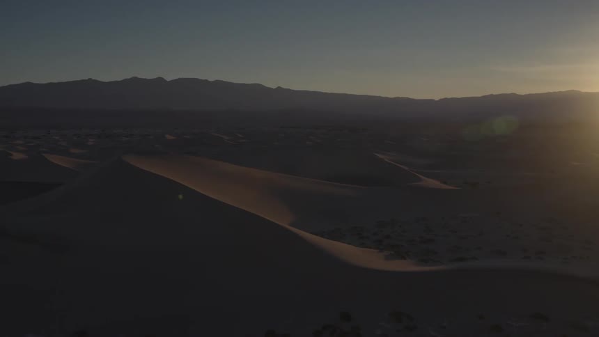 The sun is setting over the desert
