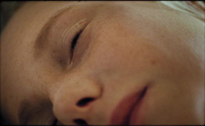 A girl is lying down and blinking his eyes