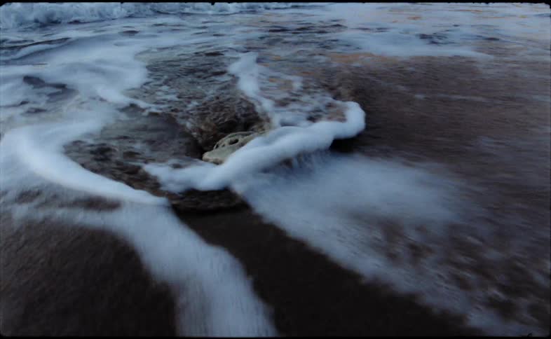 Close up view of ocean waves at the beach is displayed