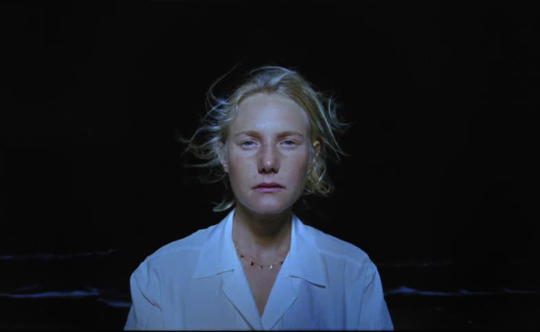 A woman is standing outdoors during the night time