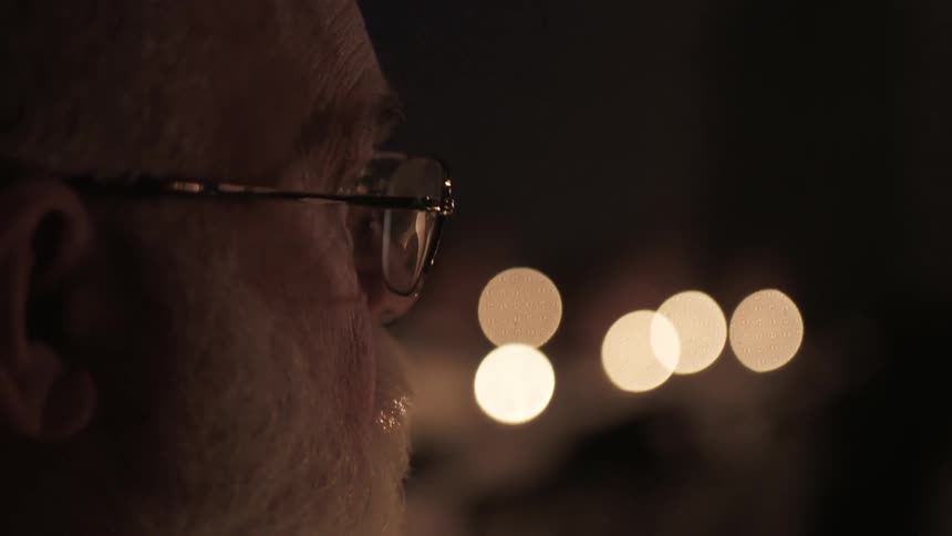 An elderly man watching something in the distance