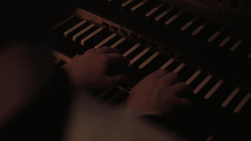 A man is playing a instrument in a dark area