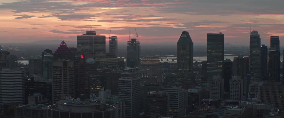 Lights come up in downtown buildings as the sun rises