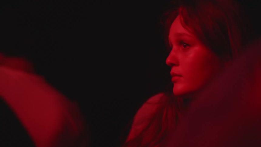 A woman appears bored while dancing in a crowded club