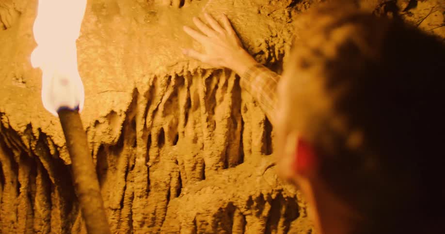A man is inside of a cave in the middle of the night time
