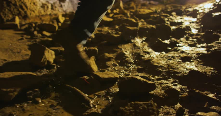 A person is walking up a rocky terrain at night