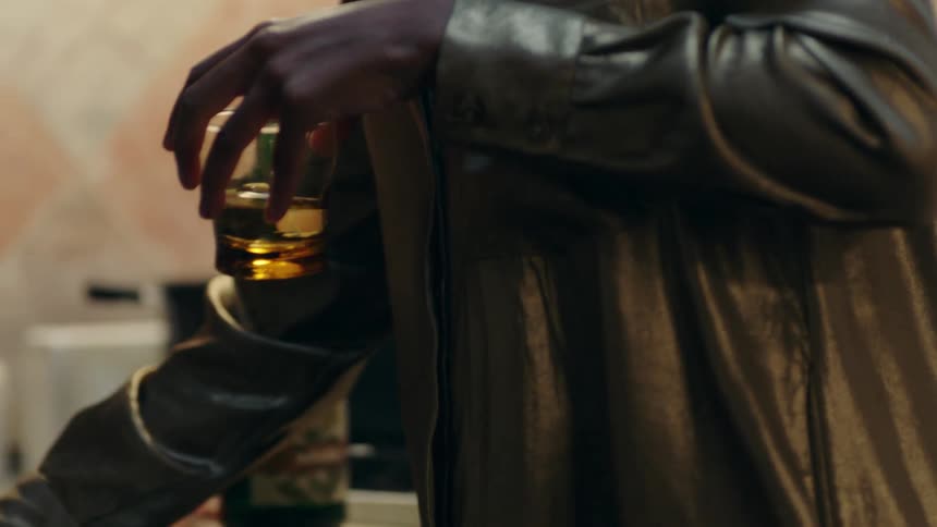 A man is putting away alcoholic drinks in the sink