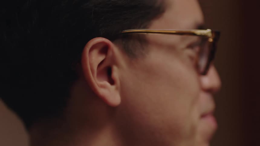 A man is talking to someone and sitting indoors