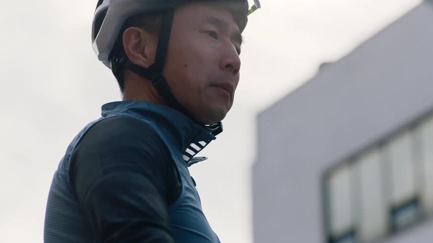 A man is riding a bike and wearing a helmet