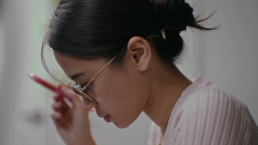 Woman peruses then makes marks in red ink