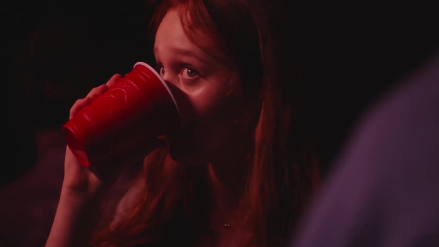 A young woman is at a club and she is partying