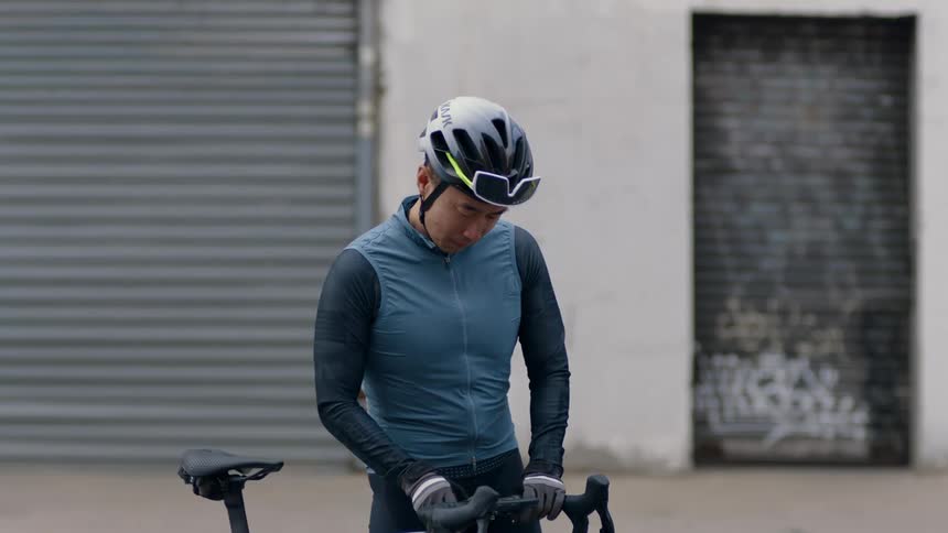 A man is riding his bike while wearing a helmet
