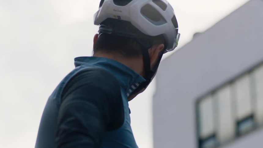Cyclist with helmet and jersey shirt looks around