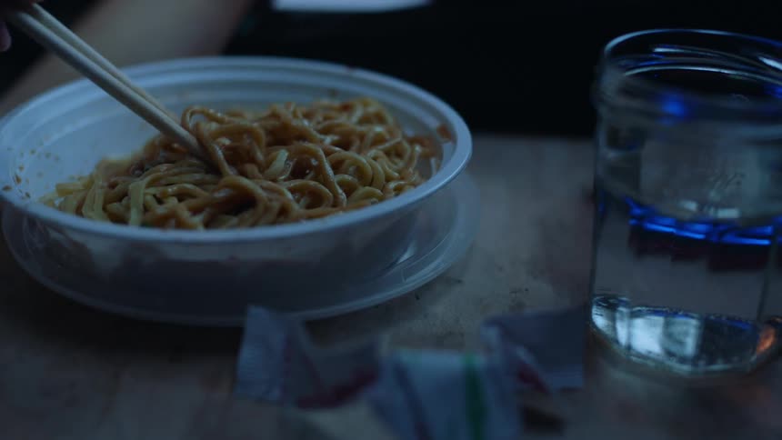 A person is eating a plate of pasta while athome