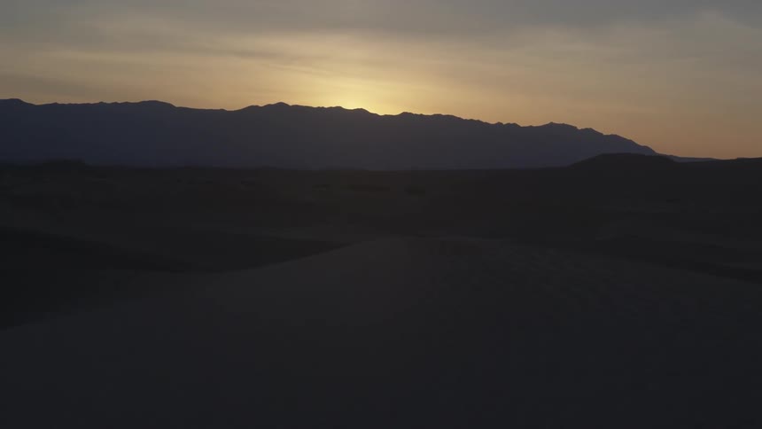 The sun is rising behind a mountain